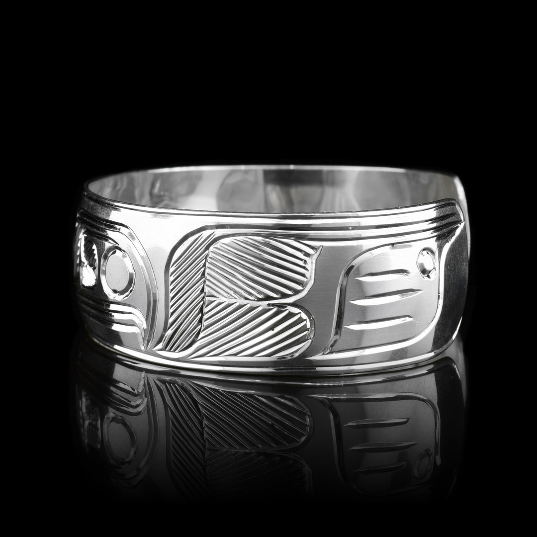 This sterling silver cuff bracelet has a wide band and there are deep carvings on the surface of it that depict the Thunderbird.