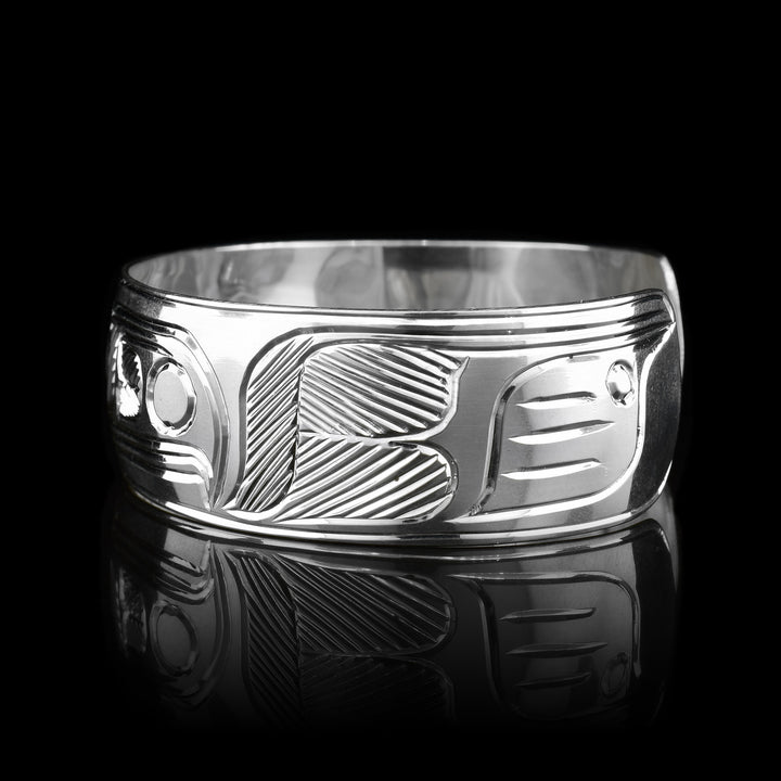 This sterling silver cuff bracelet has a wide band and there are deep carvings on the surface of it that depict the Thunderbird.