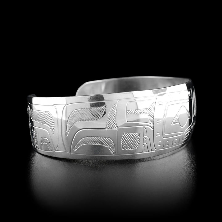 Left angle photo of the bracelet shows carved designs representing the wolf's body and fur. Both sides are identical.