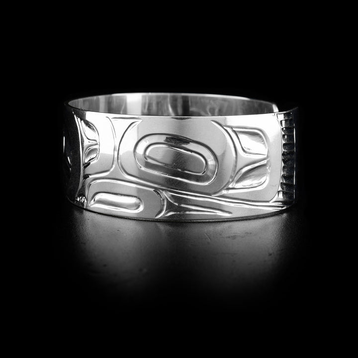 The wide, sterling silver cuff bracelet has a depiction of the Eagle carved into it.