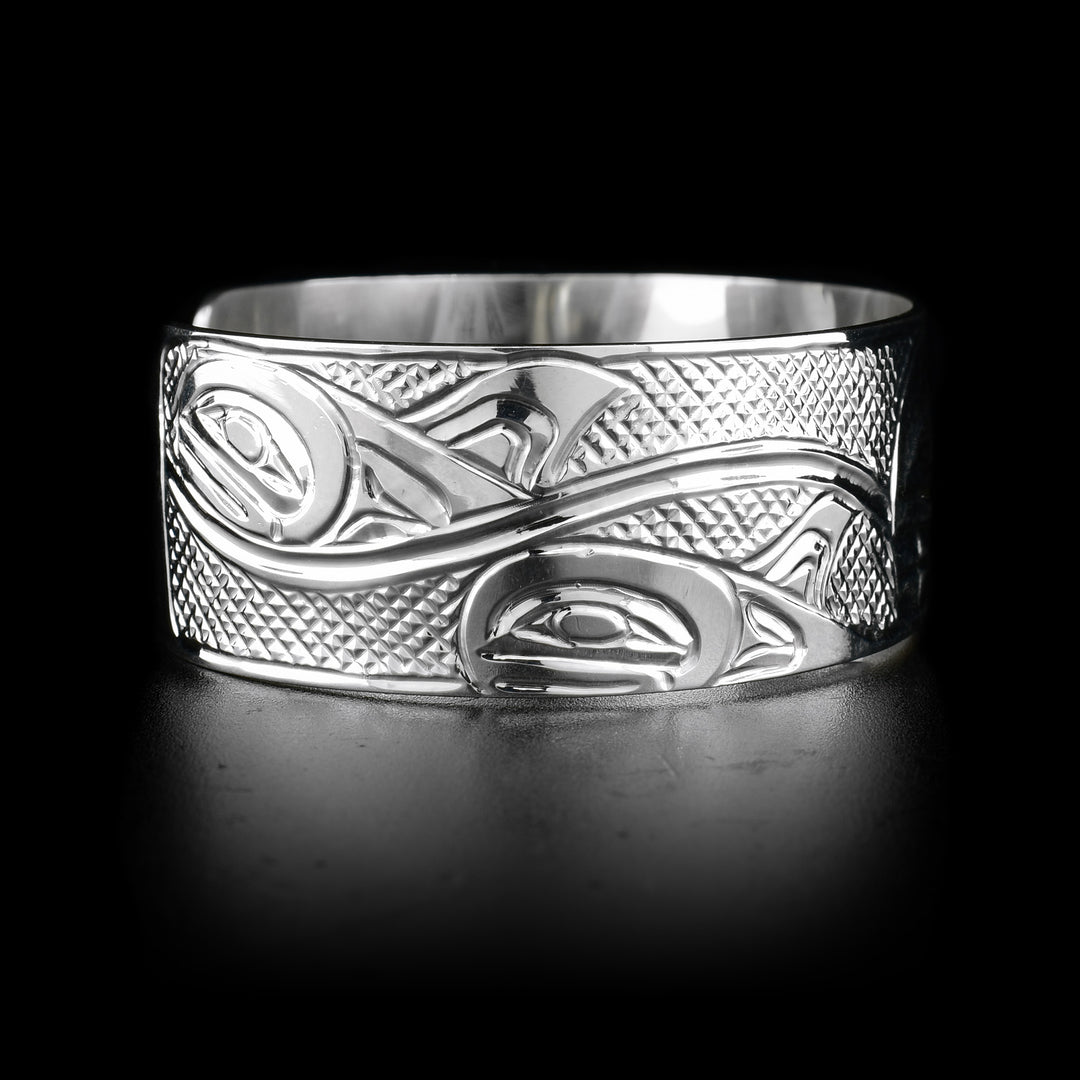 This sterling silver cuff bracelet has depictions of the Orca carved into it. 