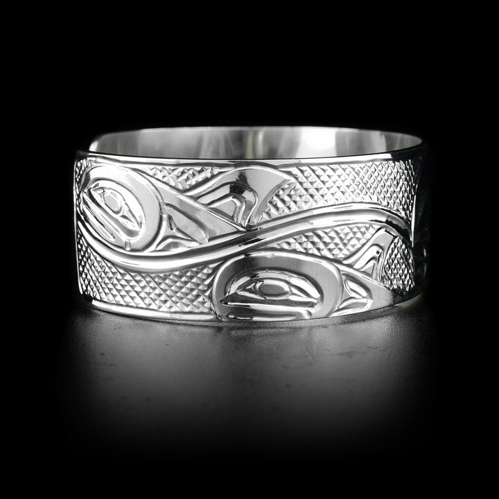 This sterling silver cuff bracelet has depictions of the Orca carved into it. 