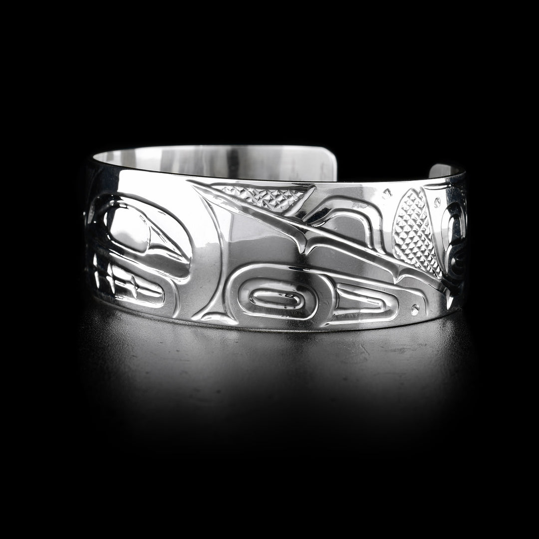 This sterling silver cuff bracelet has depictions of the Orca carved into it. 