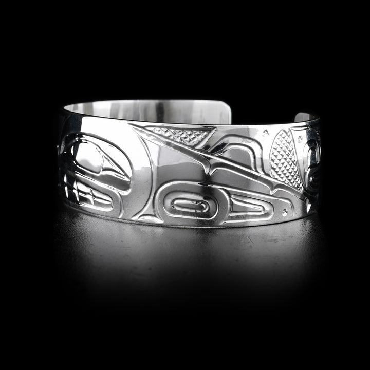 This sterling silver cuff bracelet has depictions of the Orca carved into it. 