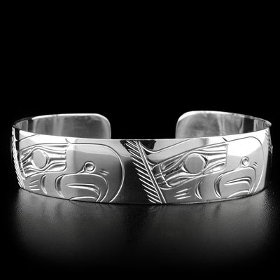 This eagle bracelet depicts the head of four eagles all facing the right carved throughout the bracelet. Each eagle has a large, pointy beak and a feather on its head.