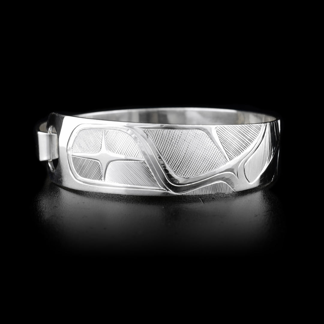 This sterling silver, tapered Orca bracelet has a depiction of the Orca carved into it.