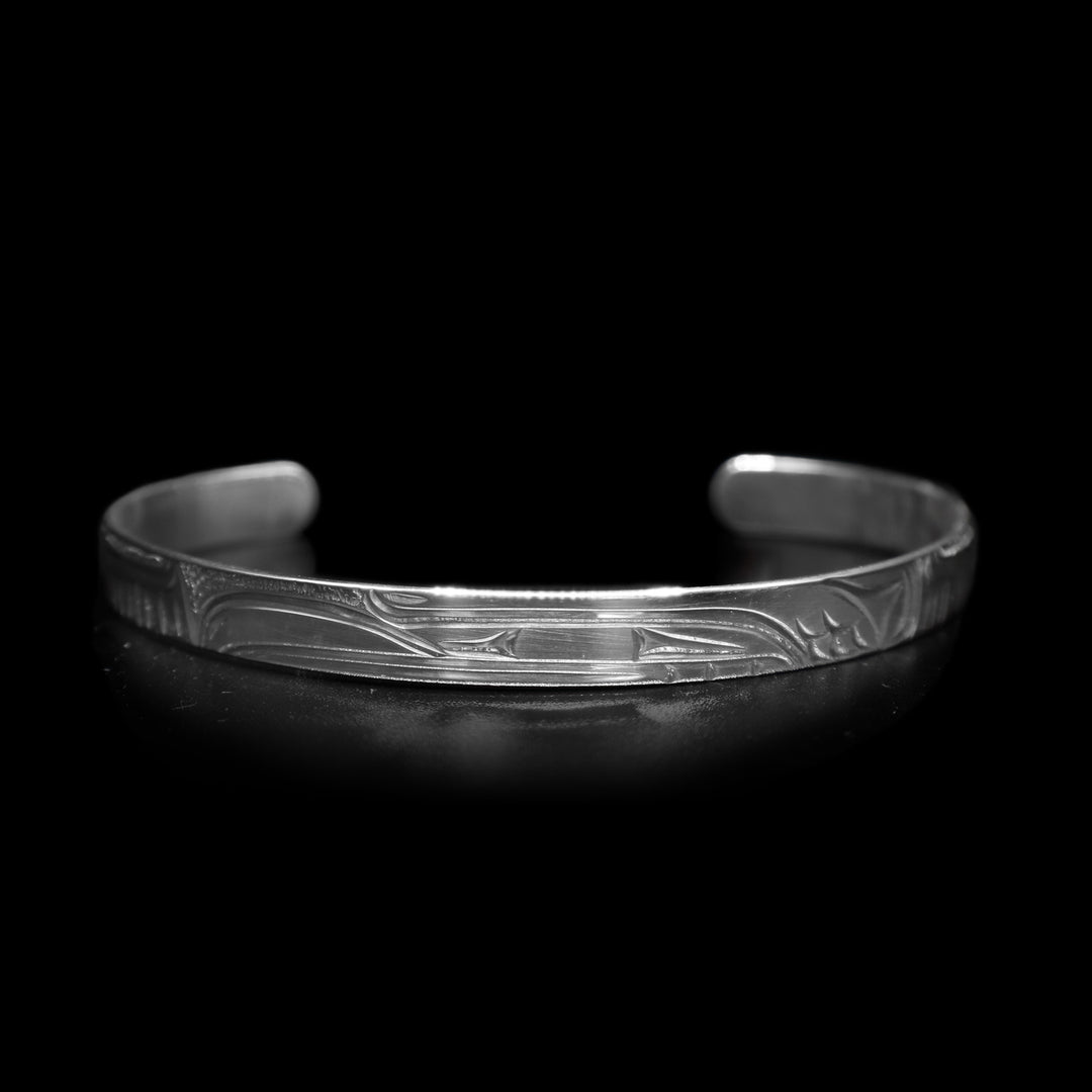 This dainty bracelet has a thin, sterling silver band with a gap in the back. There is a depiction of the Raven that has been beautifully carved into the surface of the band.
