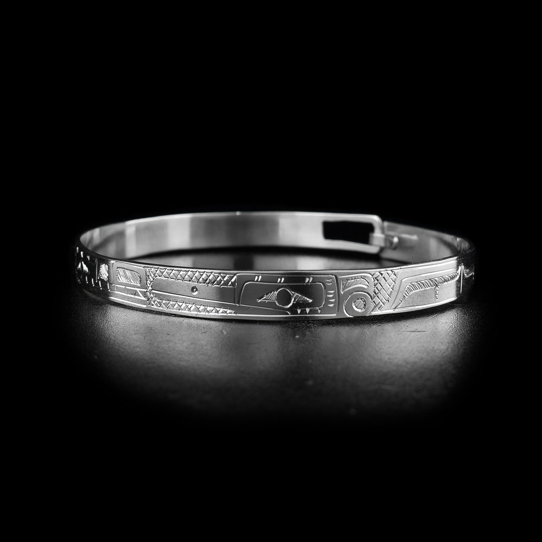 This thin bangle bracelet has a single, thin band made from sterling silver with a clasp in the back. There are depictions of the full body of the Hummingbird and Wolf legends carved into the piece at a side profile. The faces of the legends meat at the top of the band.