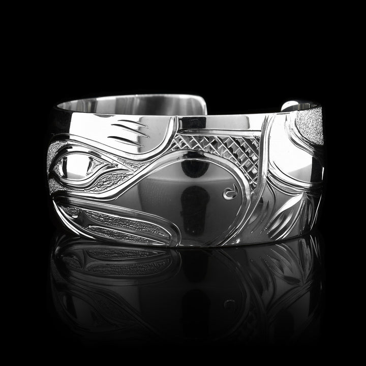 This stunning Eagle bracelet cuff has been made using sterling silver and has a single, wide band with a gap in the back. There is a beautiful depiction of the face of the Eagle that has been intricately carved into the surface of the band. There are dimpled, textured designs made around the negative space of the depiction.