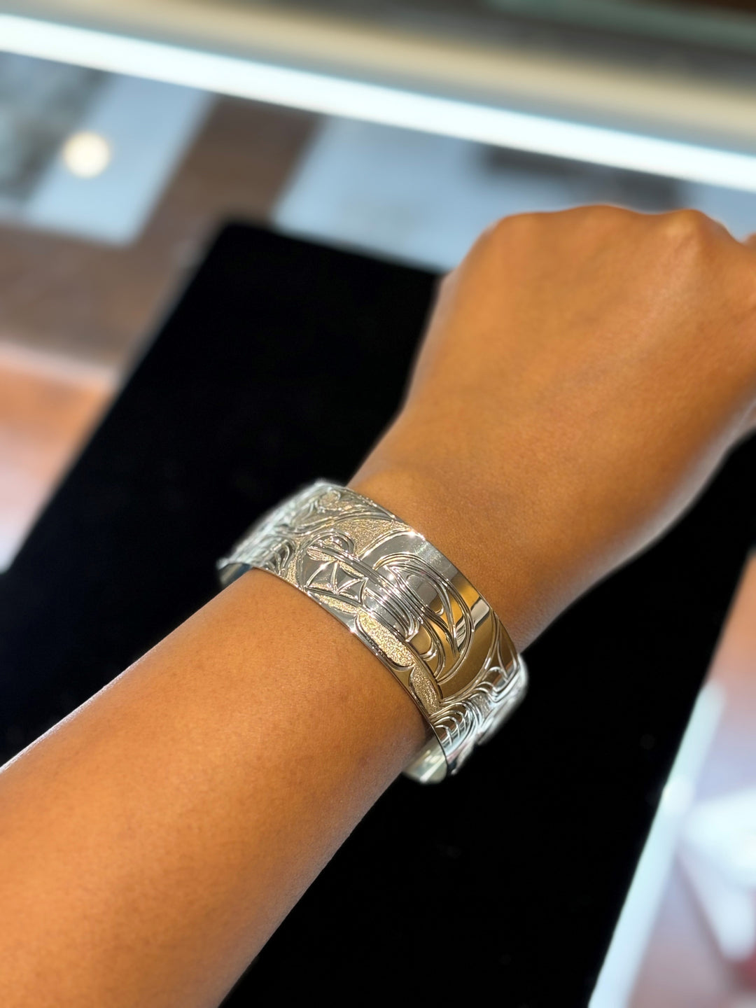 The photo shows the model wearing the wide cuff bracelet on their wrist.