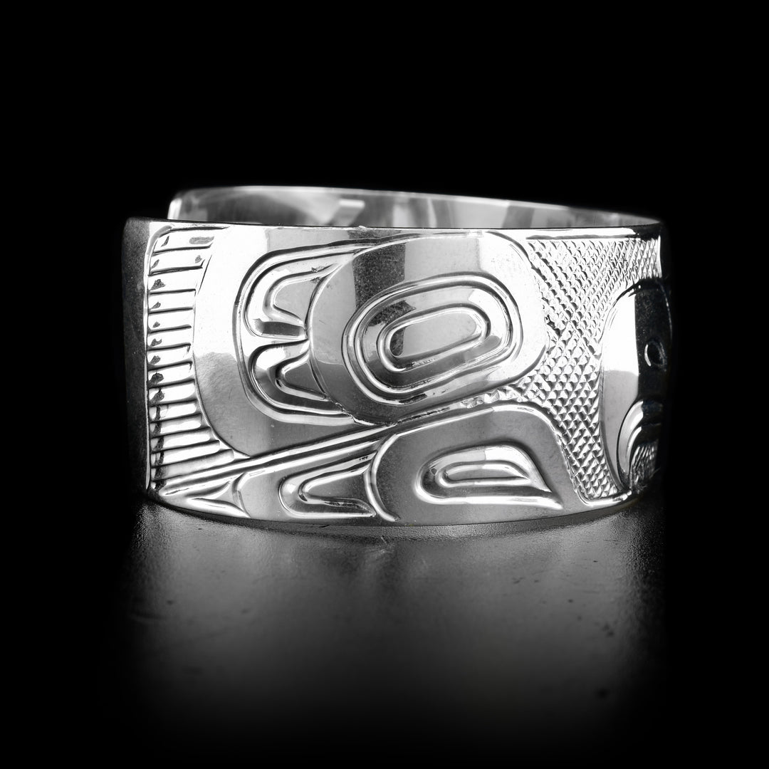 The wide, sterling silver cuff bracelet has a depiction of the Eagle carved into it.