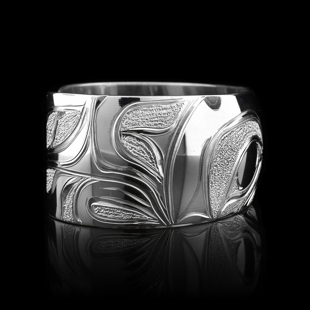 This Wolf bracelet cuff has been made using sterling silver and has a single, wide band with a gap in the back. There is a fabulous depiction of the Wolf that has been intricately carved into the surface of the band. There is a textured, dimpled designs that have been made around the Wolf.