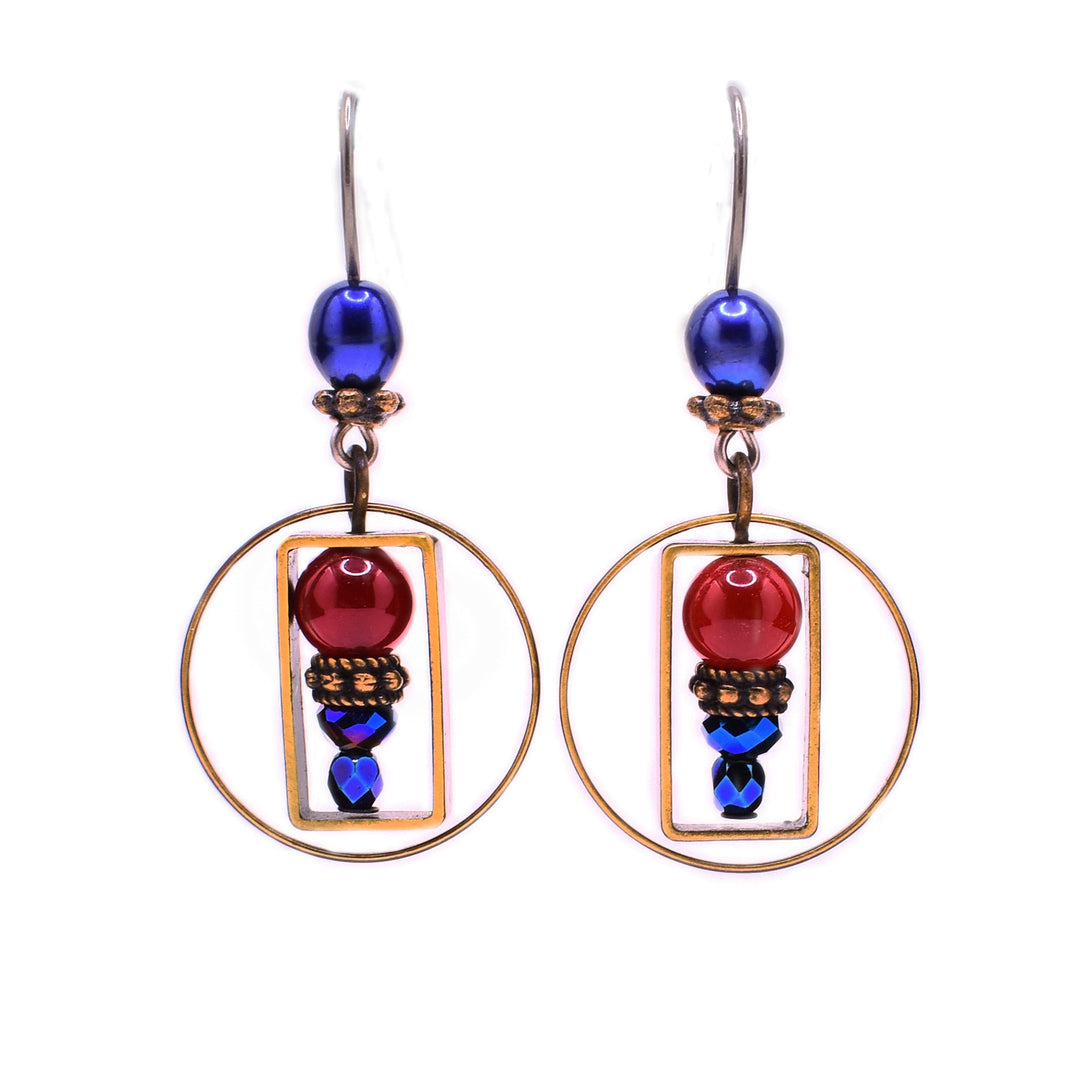 These dainty earrings feature a red carnelian agate with brass accents and glass beads underneath encased in a rectangular brass accent. Surrounding the rectangle is a circular brass accent thats hanging from a blue pearl at the top of each earring.