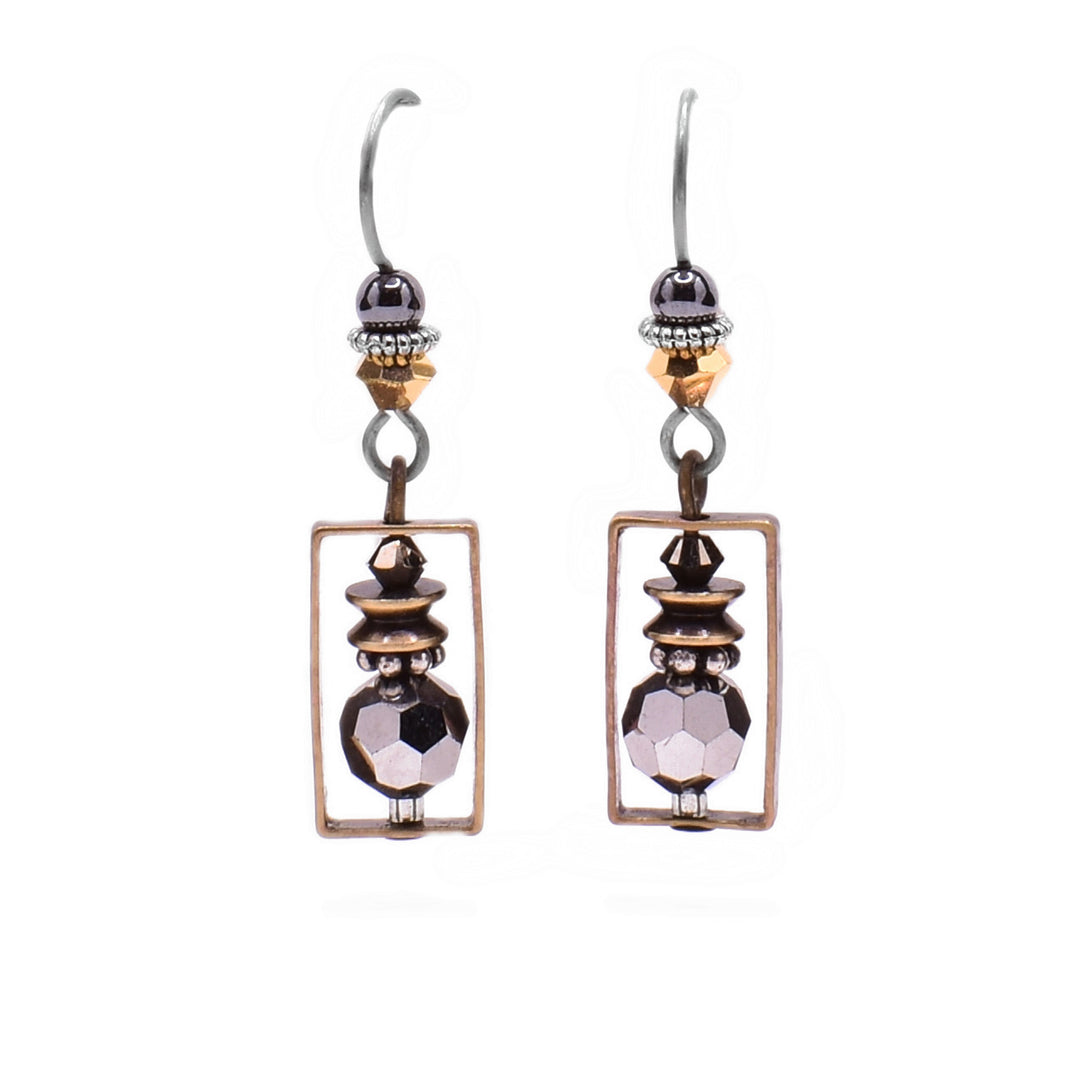 These dainty crystal earrings feature a rectangular brass accent in which there is a grey Austrian crystal with brass and silver accents. Above is a yellow crystal with a hematine bead.
