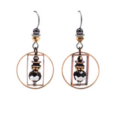 These dainty earrings feature a circular brass accent encasing a brass rectangle in which there is a grey Austrian crystal and additional brass accents. Above the circle is a yellow crystal and a hematine bead attached to the hook.