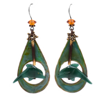 These dolphin earrings feature a teardrop copper accent with a green acrylic dolphin in front of it. There is a brass bar attaching the dolphin to the top of the earring where an oval Baltic amber is.