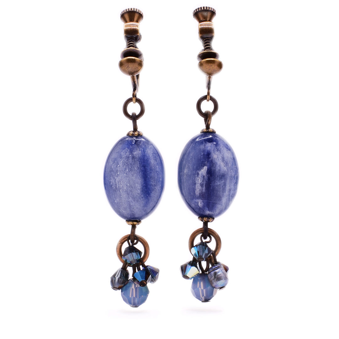 These clip earrings feature an oval, blue kyanite in the center with a cluster of dark and light blue gemstones attached at the bottom.