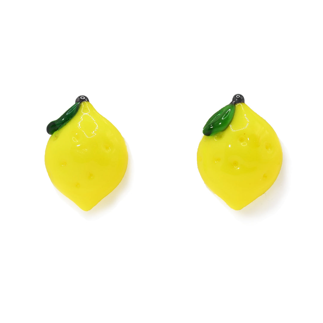 These lemon earrings are made from lampworked glass and have lemon shaped, yellow glass with dimples across its surface. There is a green leaf with a brown stem at the top.
