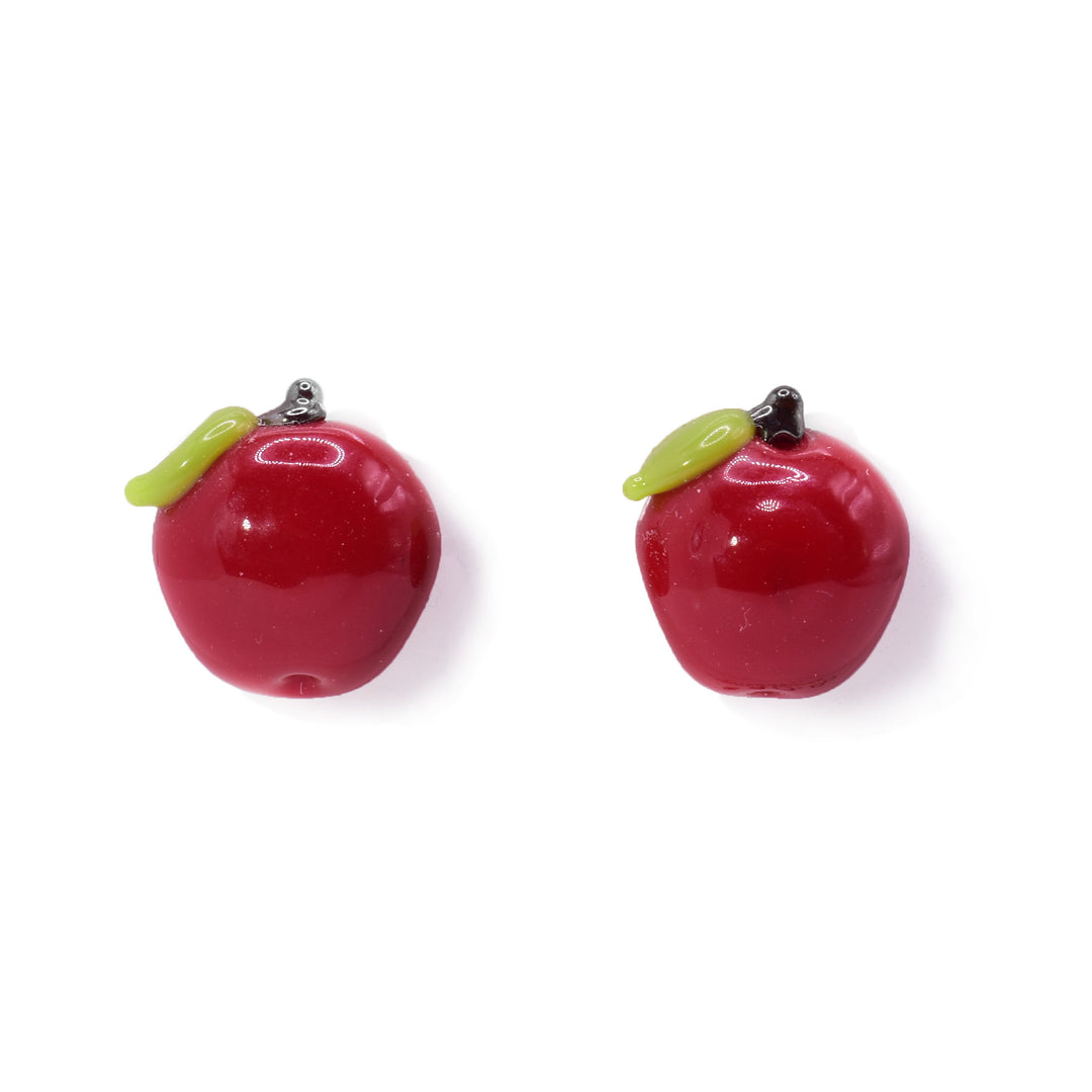 These apple stud earrings are made from lampworked glass and are apple shaped. There is red class that are round shaped and have a green leaf next to the brown stem at the top.
