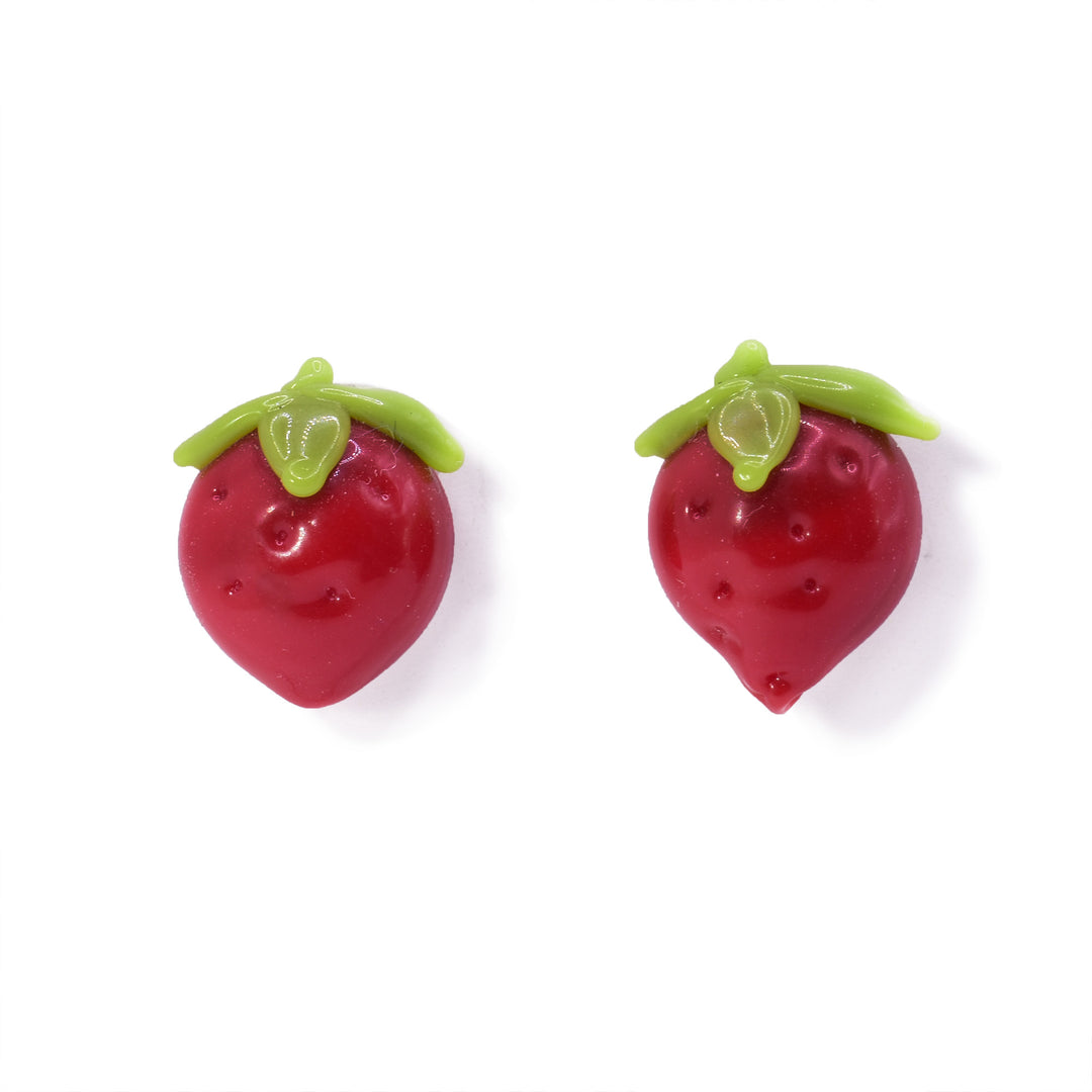 These Strawberry earrings studs are made from lampworked glass. There is a round piece of red glass that tapers at the bottom and has dimples made across its surface. There are three, green leaves and a stem at the top of the piece.