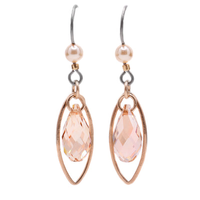 These teardrop earrings feature a teardrop-shaped crystal with an oval gold-filled accent behind. Above the crystal, connected to the titanium hook, is a white crystal pearl.