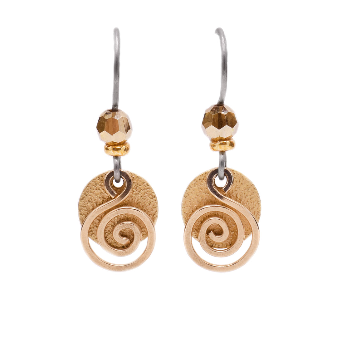 These delicate earrings depict a circular brass accent with a swirl-shaped gold-filled wire in front. Above is a circular, yellow crystal attached to the titanium hook.