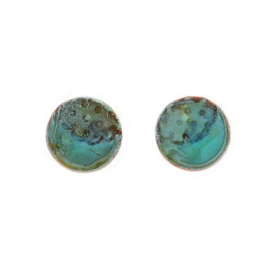 These patina earrings are circular in shape and have unique designs on them mimicing an ocean and its waves. The colours include light green, light blue, light brown.