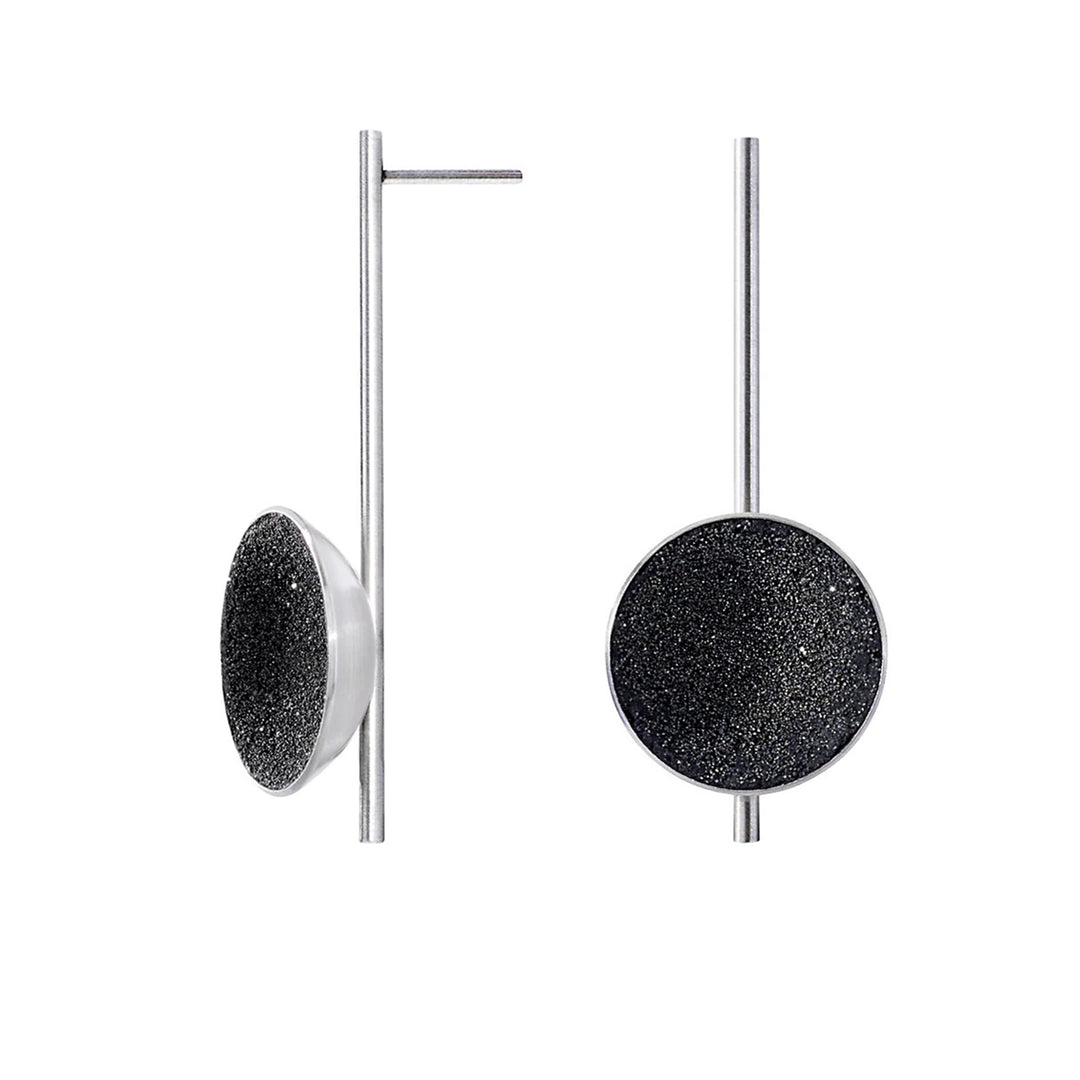 These stainless steel drop earrings feature a long, skinny post with a black-tinted, shiny circle attached at the front and bottom making up the centerpiece.