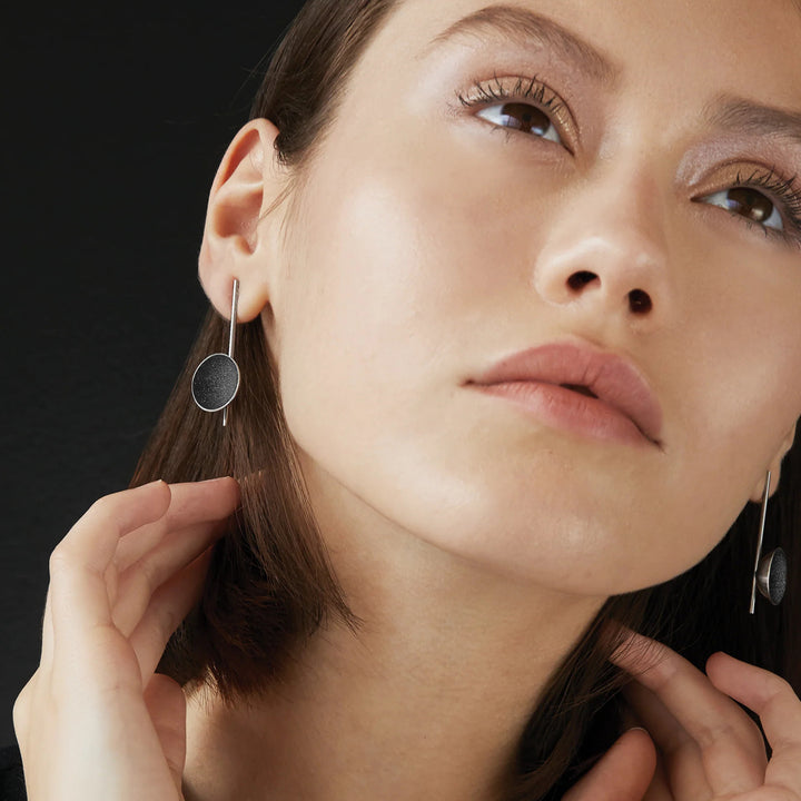 This photo shows the stainless steel drop earrings on a female model.