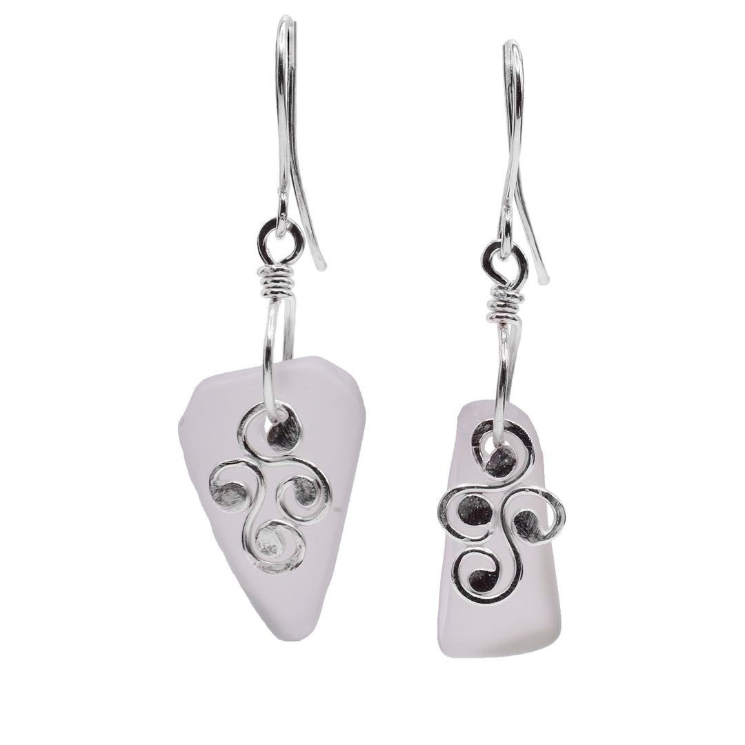 These sea glass drop earrings have misshapen glass hangs with swirling sterling silver charms hanging in front of them. There are four swirls that represent water. 