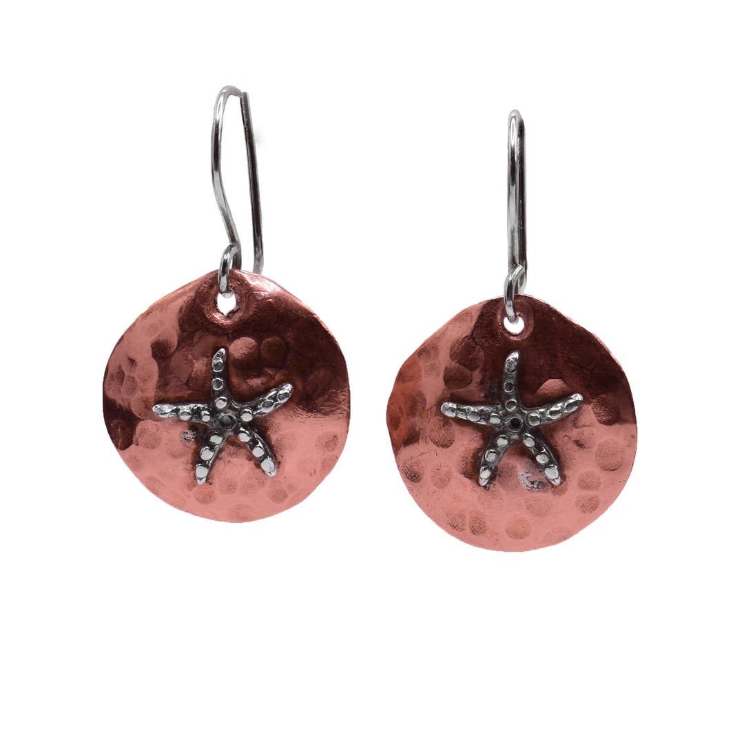 These sea star earrings have small, circle shaped hangs made from copper. There are dimples made in the surface of the hangs and a sea star charm in the center of them. The starfish is made from sterling silver and there are circle shaped in the surface of it.