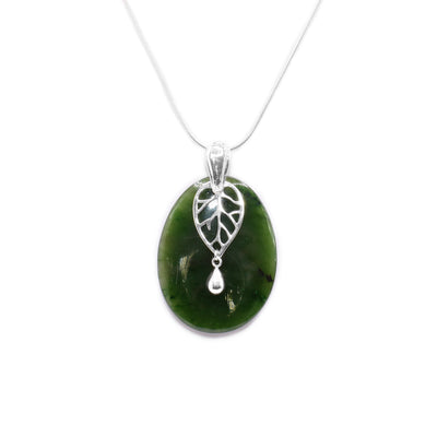 This jade pendant has a large, oval shaped BC jade stone with a cutout, sterling silver leaf charm.