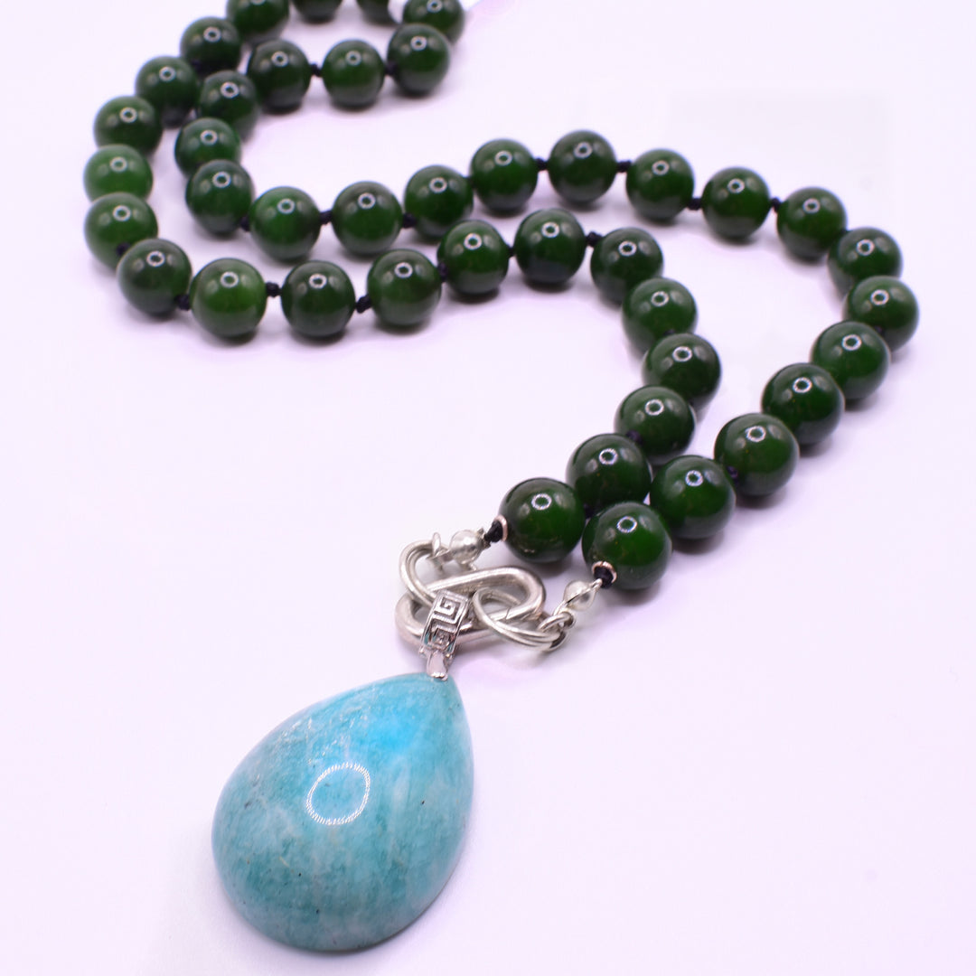 This beaded jade necklace with pendant has sphere shaped beads made from jade running around its entire length. The ammonite pendant hangs at the bottom.