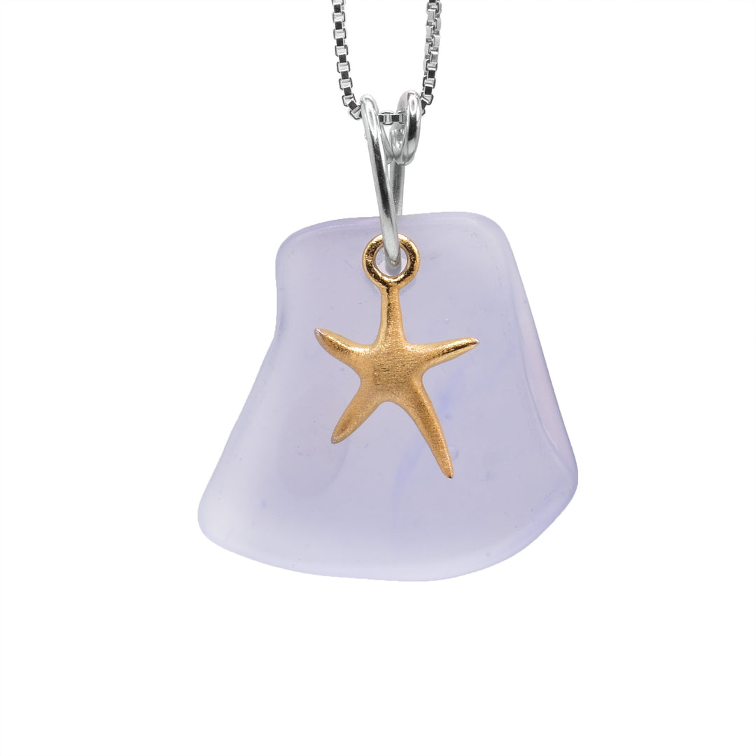 These gold Starfish Pendant necklace has a rough shaped piece and sea glass with a gold charm resting in the front of the piece. The gold charm looks like a starfish with five arms.
