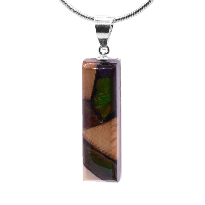 This ammolite gemstone and mammoth ivory pendant has a thin rectangle shaped and a sterling silver jump ring.