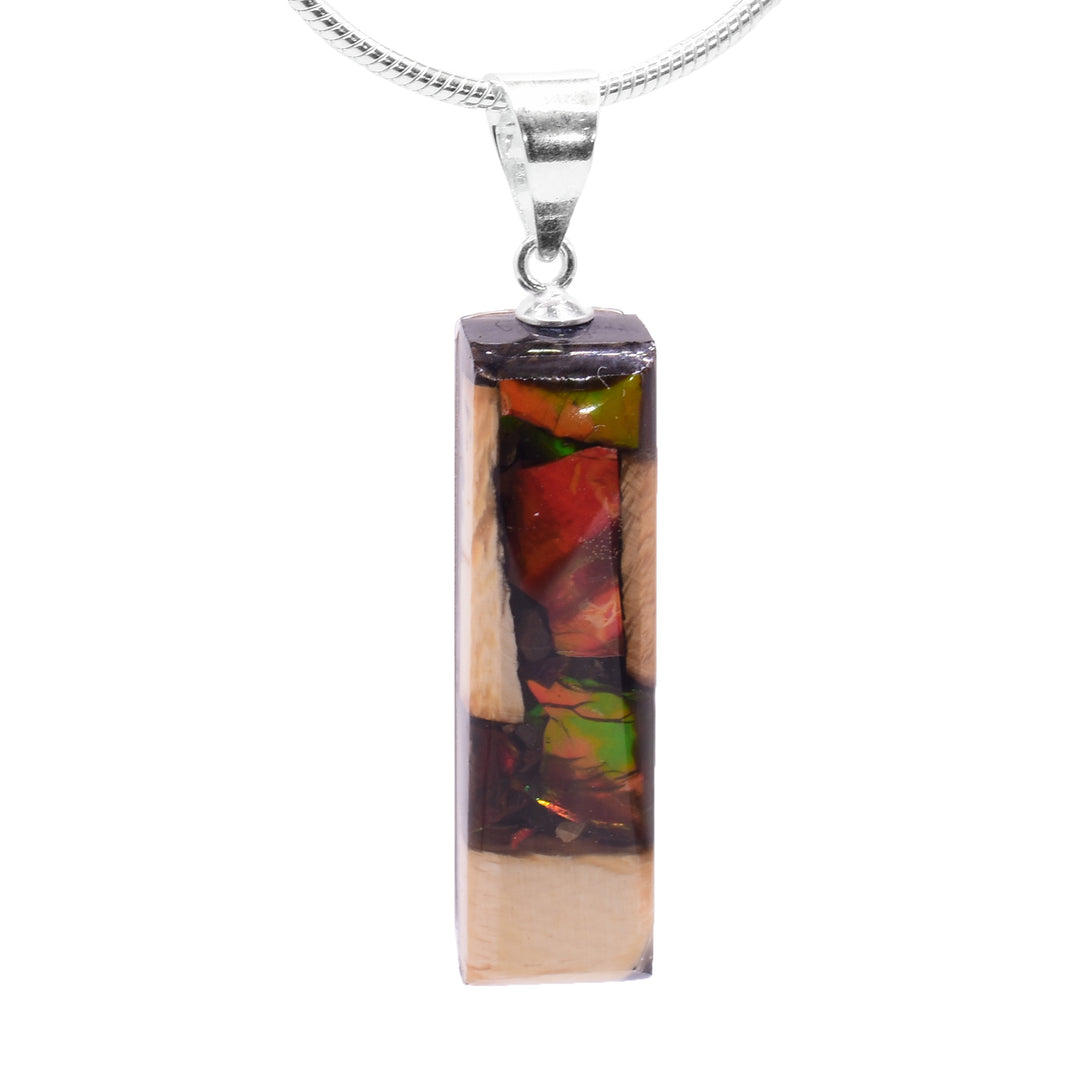 This ammolite gemstone and mammoth ivory pendant has a thin rectangle shaped and a sterling silver jump ring.