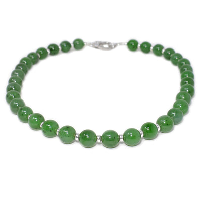 This jade necklace is made up of small jade beads with sterling silver accents in between and a clasp at the back.