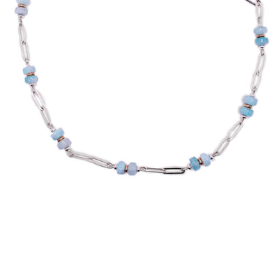 This necklace has a large silver chain with round aquamarine beads. 