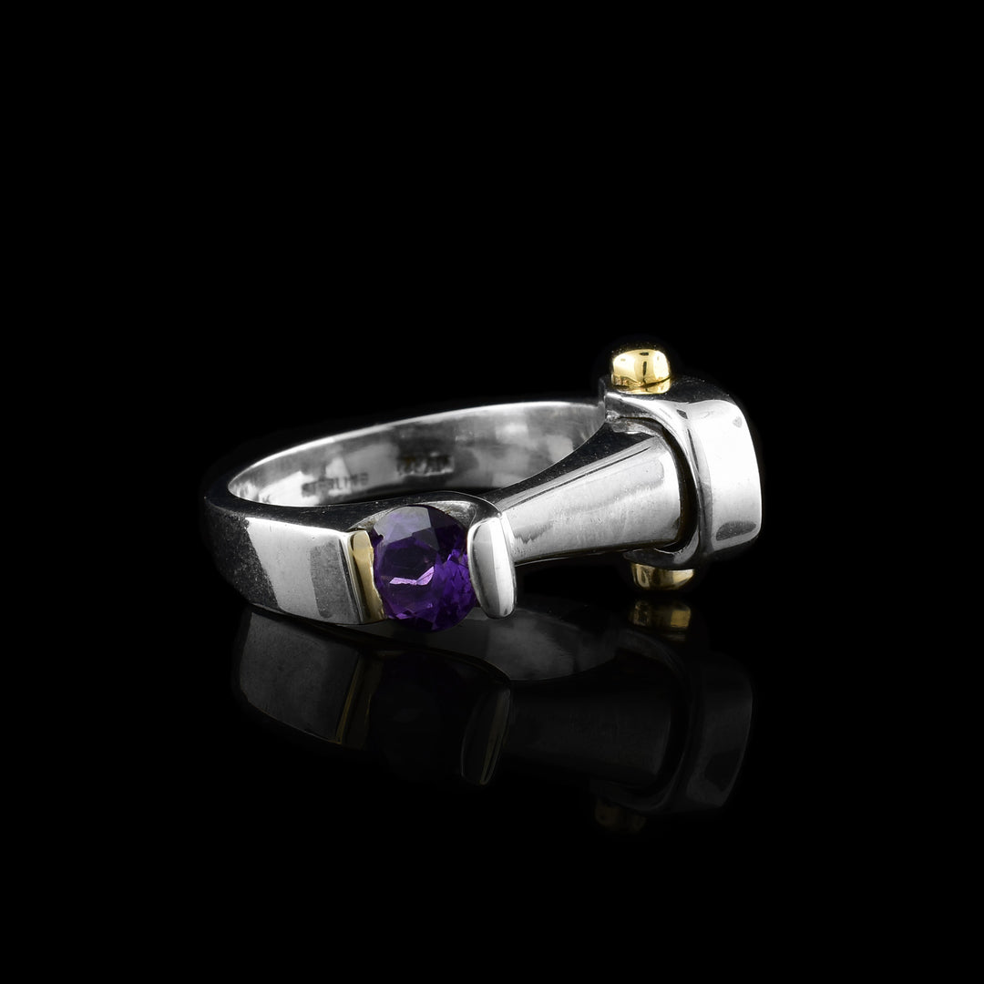 This abstract dainty amethyst ring is made from sterling silver and has an asymmetrical signet. on either side of the ring is a 14K gold and an amethyst gemstone.