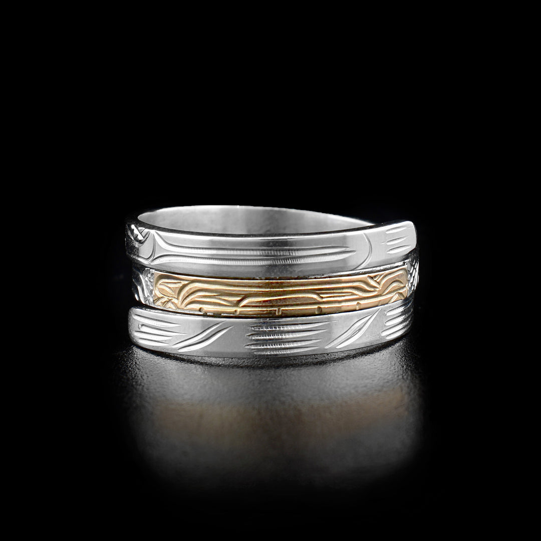 This wrap ring has three layers with the middle one depicting the head of a bear facing the right made from gold. The remainder of the ring is silver and depicts the animal's paws and body. 