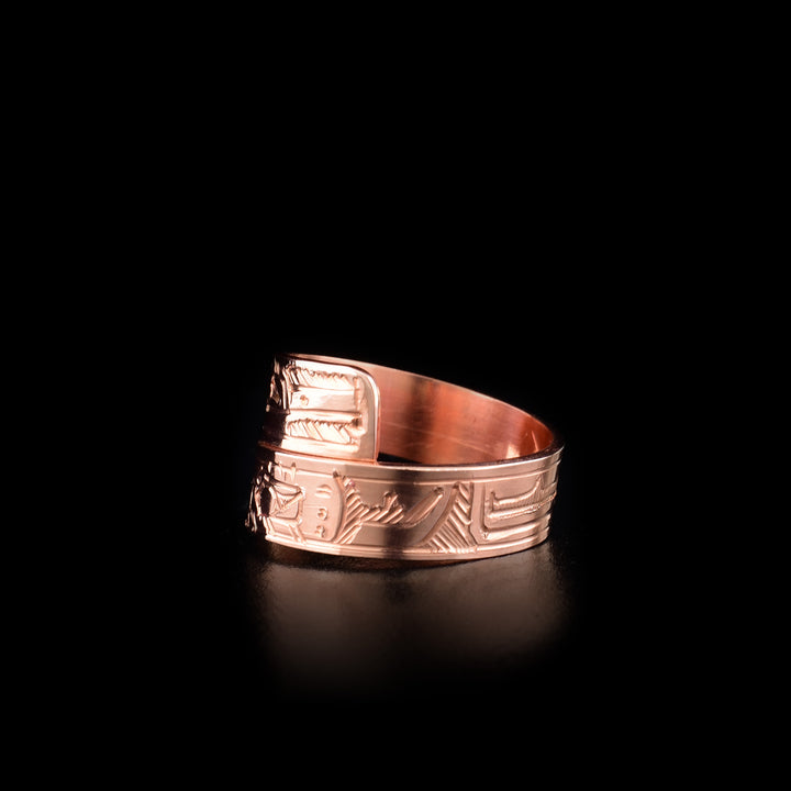 This copper ring has a band that wraps around the finger twice. There are depictions of the Hummingbird and the Raven carved into the surface of the band.