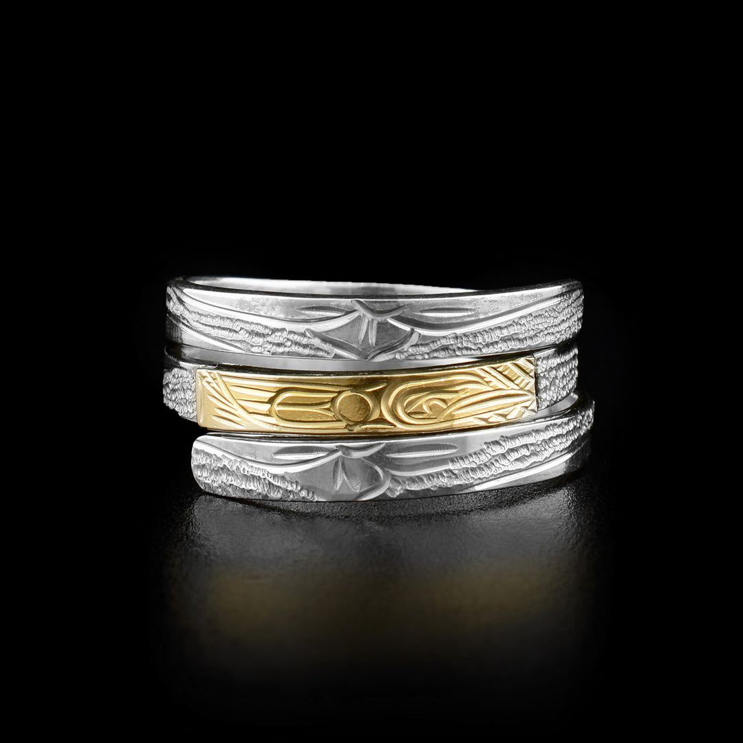 This wrap ring has three layers with the middle one depicting the head and wing of a hummingbird mid-flight made out of gold. The rest of the ring has carvings depicting flowers.