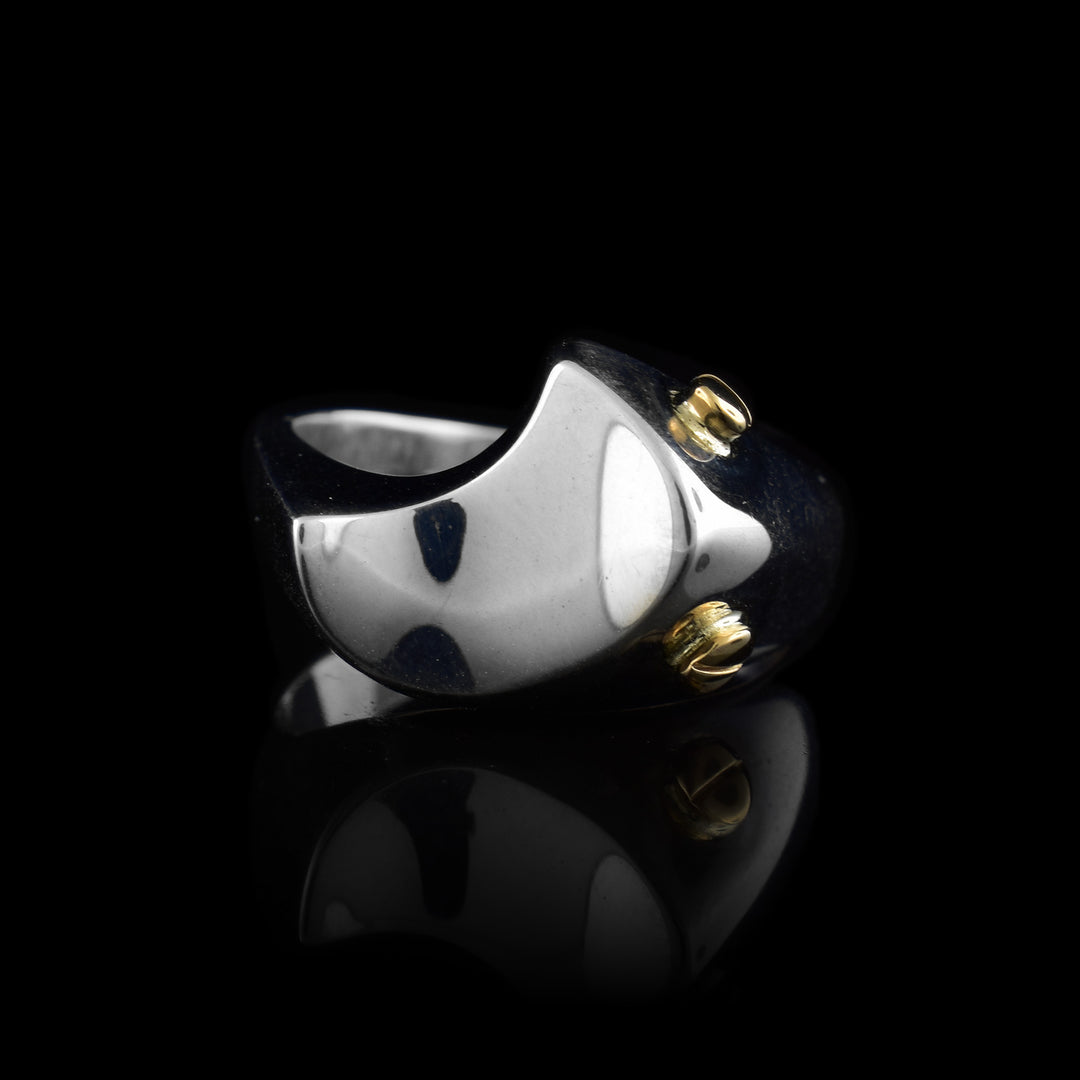 This sterling silver signet ring has a half moon shaped signet with two 14K gold studs attached to the side of the signet.