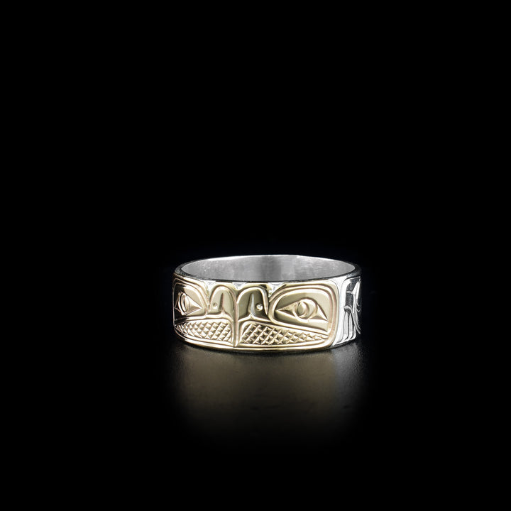 This sterling silver and 14K gold ring has two depictions of the Eagle carved into the surface of the band. The Eagles are depicted facing each other and their heads are made from 14K gold.