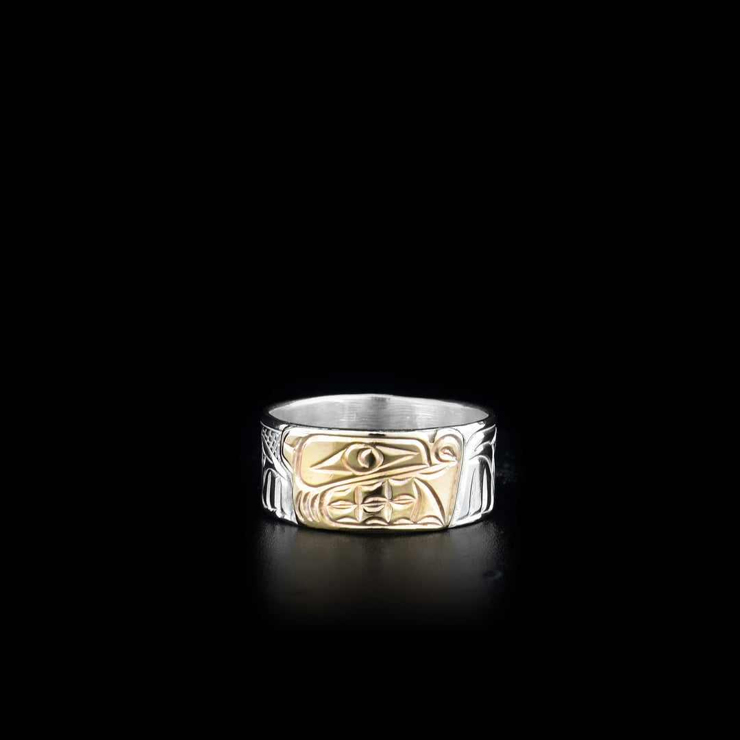 This sterling silver and 14K gold ring has carvings all over the surface of the band. There is a depiction of the Bear carved into the piece and the face of the Bear is made from 14K gold.