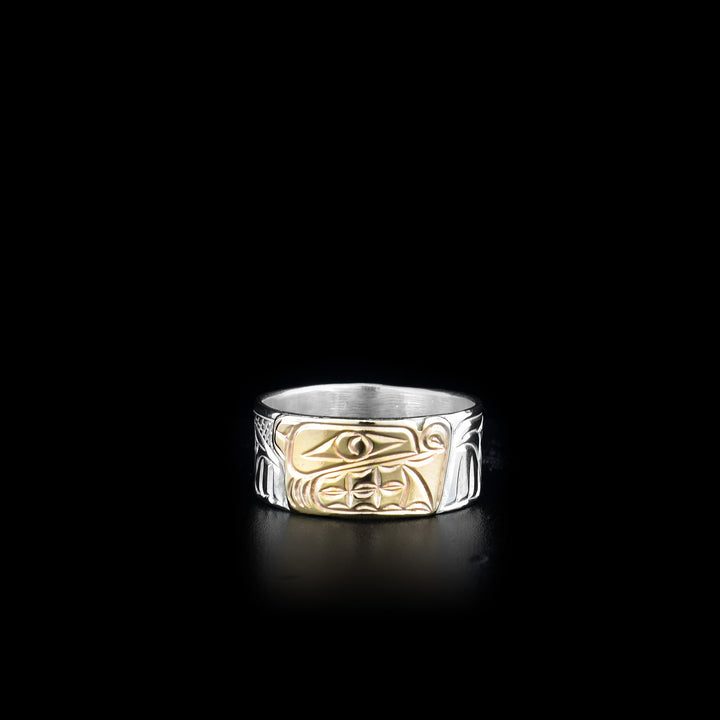 This sterling silver and 14K gold ring has carvings all over the surface of the band. There is a depiction of the Bear carved into the piece and the face of the Bear is made from 14K gold.
