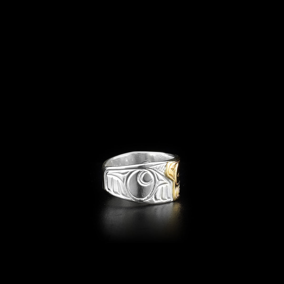 This sterling silver and 14K gold ring has carvings all over the surface of the band. There is a depiction of the Bear carved into the piece and the face of the Bear is made from 14K gold.