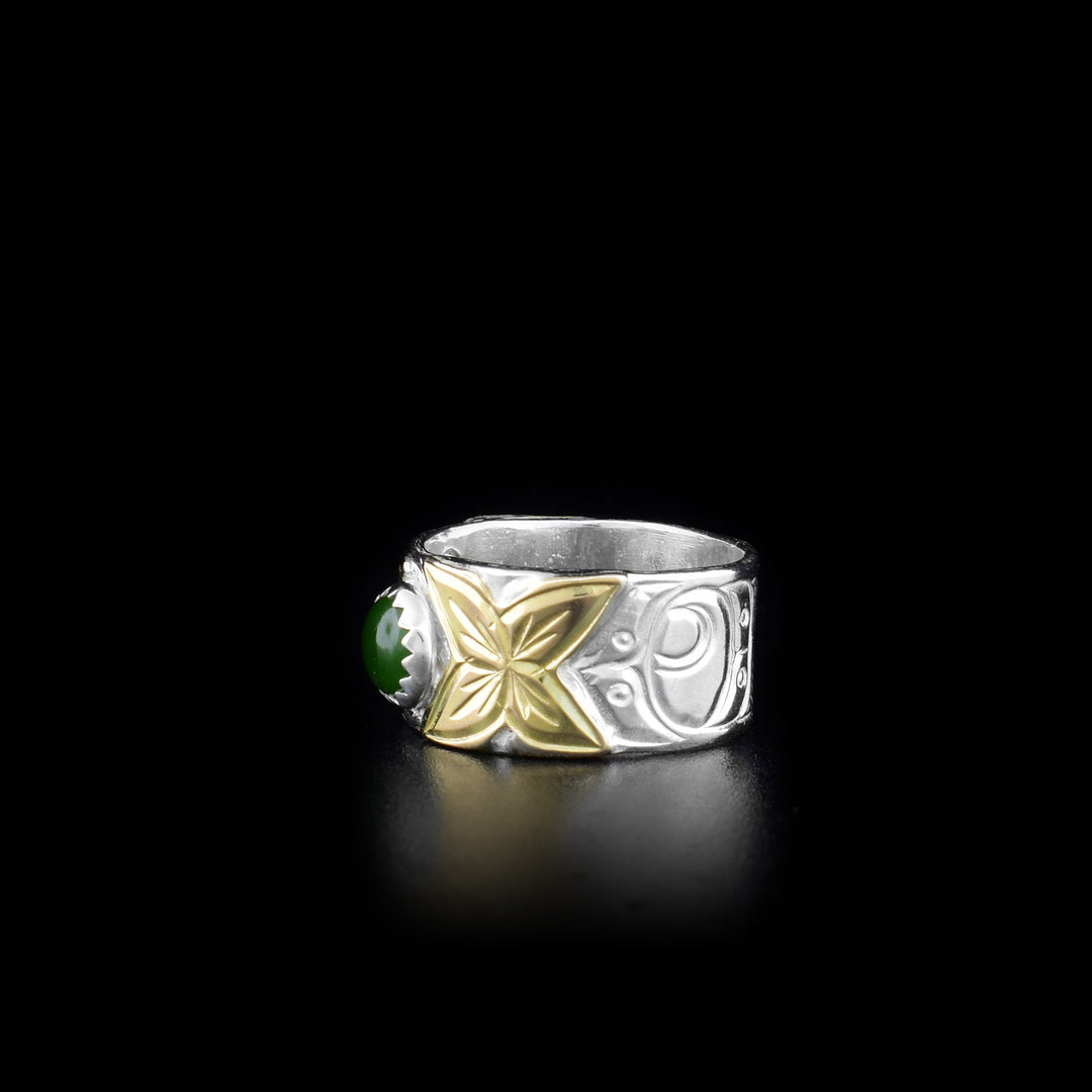 This Hummingbird ring is made from sterling silver, 14K gold and BC jade with a sing with band. There is a round, jade gem held in the center of the band and there are designs carved into the surface of the band. The carvings depict the Hummingbird and its head is made from 14K gold.