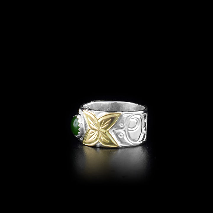 This Hummingbird ring is made from sterling silver, 14K gold and BC jade with a sing with band. There is a round, jade gem held in the center of the band and there are designs carved into the surface of the band. The carvings depict the Hummingbird and its head is made from 14K gold.