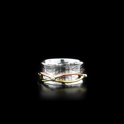 This unique spinner ring has an embossed, sterling silver band that flares out on the ends. There is a ring wrapping around the band made up of brass and copper wires connected with silver beads; this part of the ring can be spun around the band.